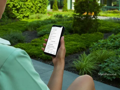 Blick über die Schulter einer Pflegefachfrau auf ihr Handy mit ihrem persönlichen Bereich